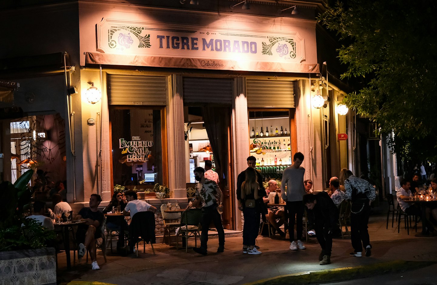 Menschen, die nachts in einem Restaurant im Freien speisen und sich unterhalten.